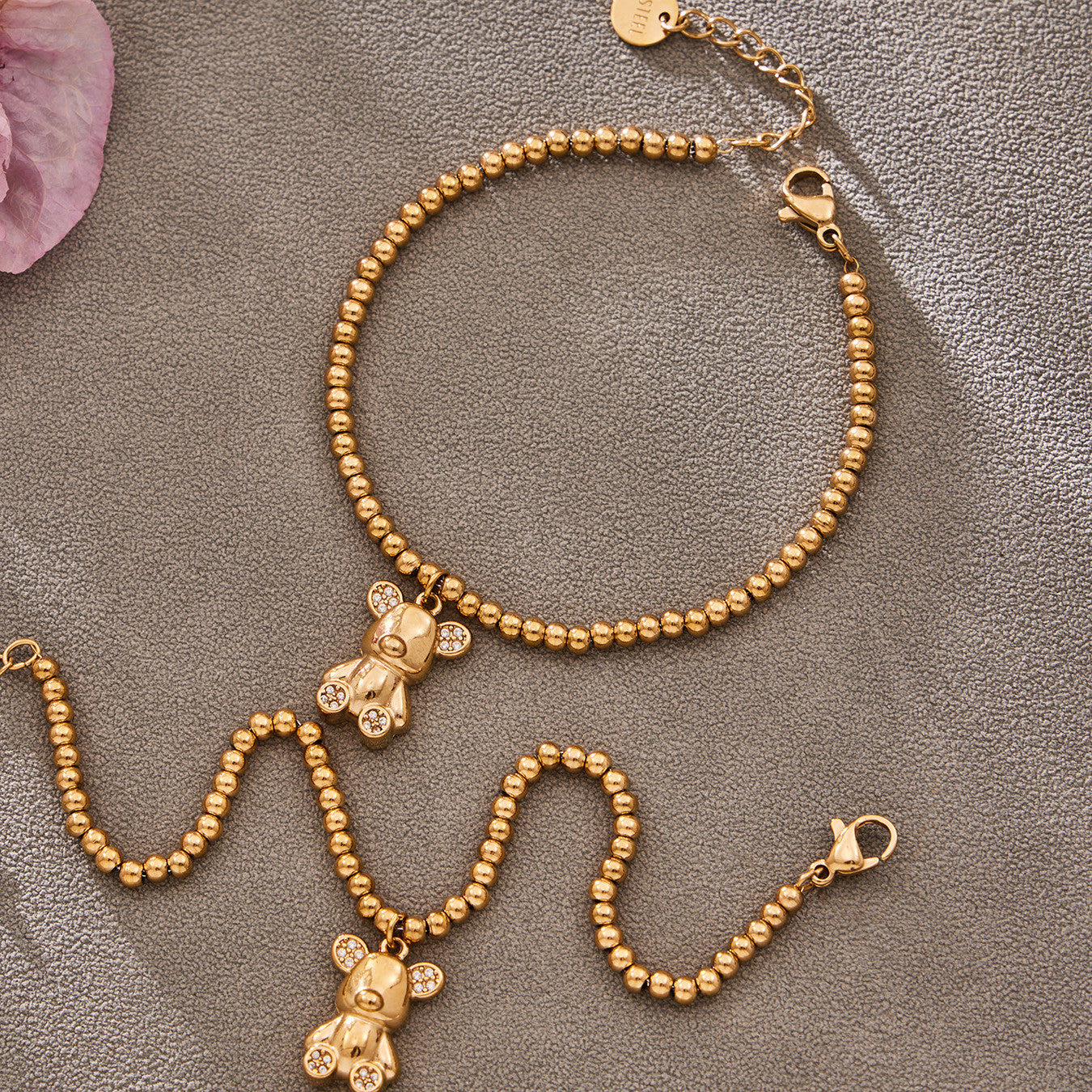 Flatlay of 316L stainless steel 18K gold PVD zircon bear bracelets, wholesale waterproof bracelets