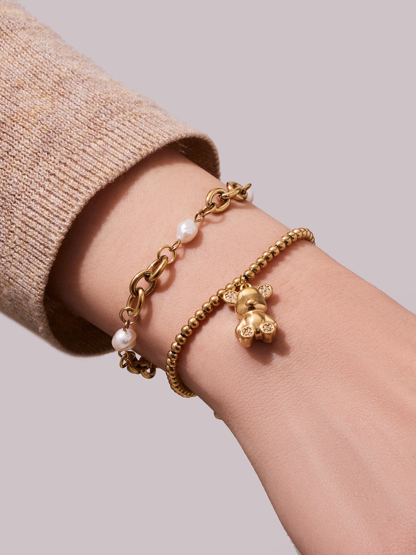 Hand wearing 316L stainless steel 18K gold PVD zircon bear bracelet, hypoallergenic stackable design