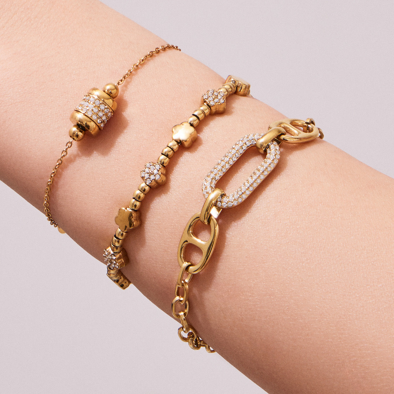 Model stacking multiple 316L Stainless Steel 18K Gold PVD star bead bracelets, layered waterproof style
