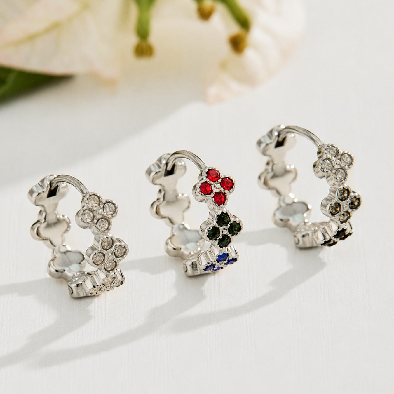 Steel four-leaf clover earrings displayed with white, multicolor and black cubic zirconia