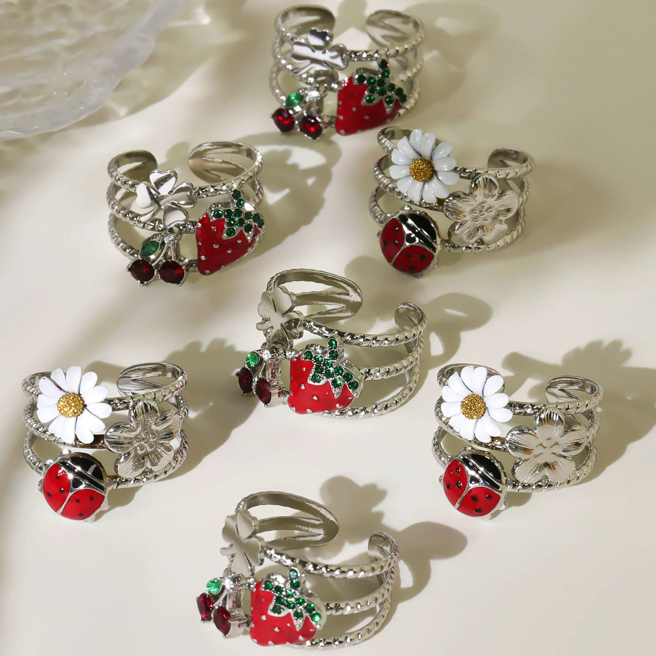 Steel-tone colorful enamel statement rings featuring daisy, ladybug and strawberry motifs
