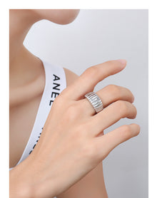 Model wearing steel croissant ribbed dome ring with wide band design for wholesale boutique jewelry buyers