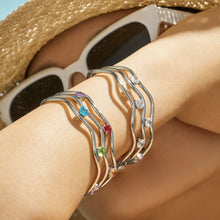 Model wearing a polished steel three-layer cubic zirconia open bangle