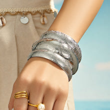 Model wearing a polished steel floral engraved wide bangle