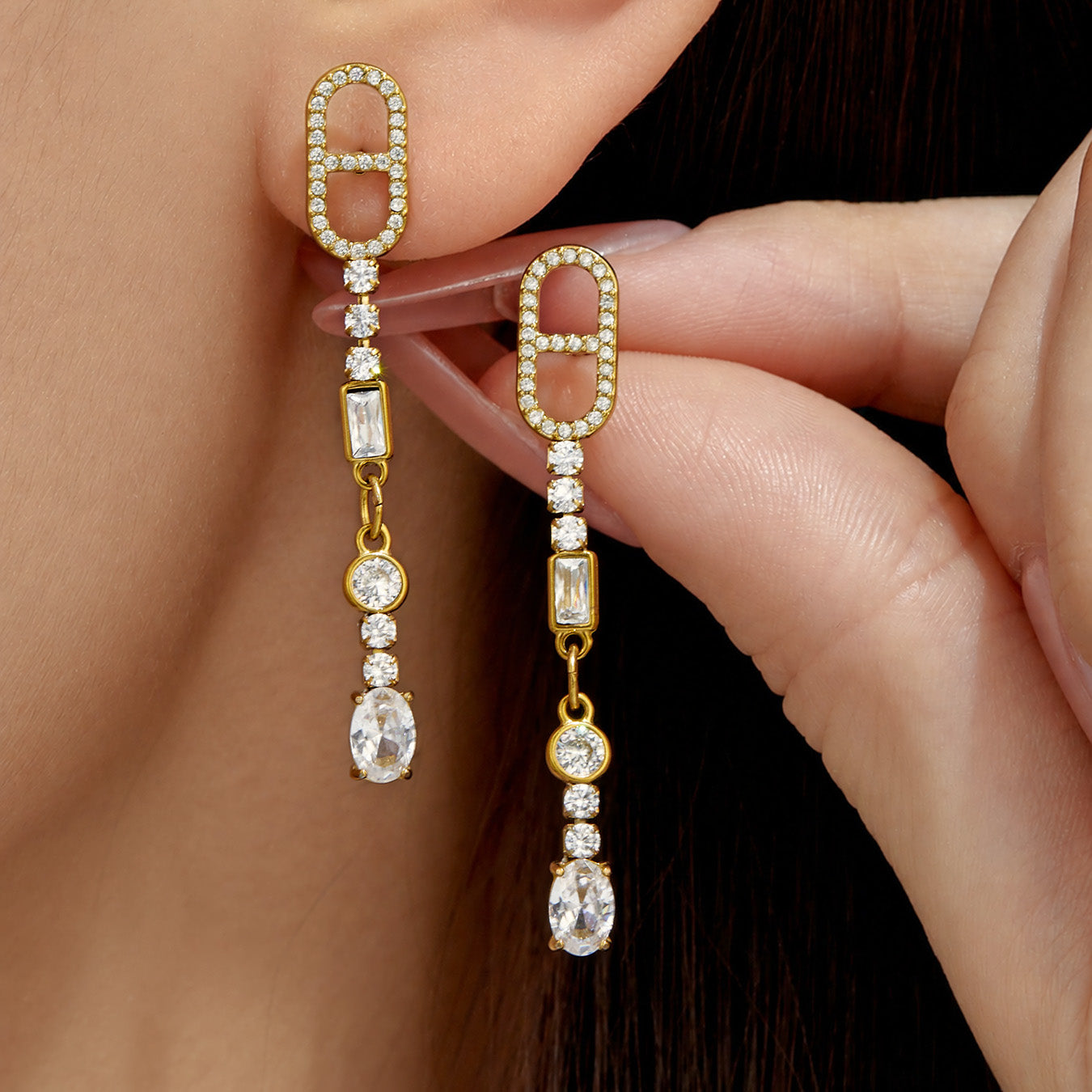Steel-tone geometric cubic zirconia drop earrings shown beside the ear