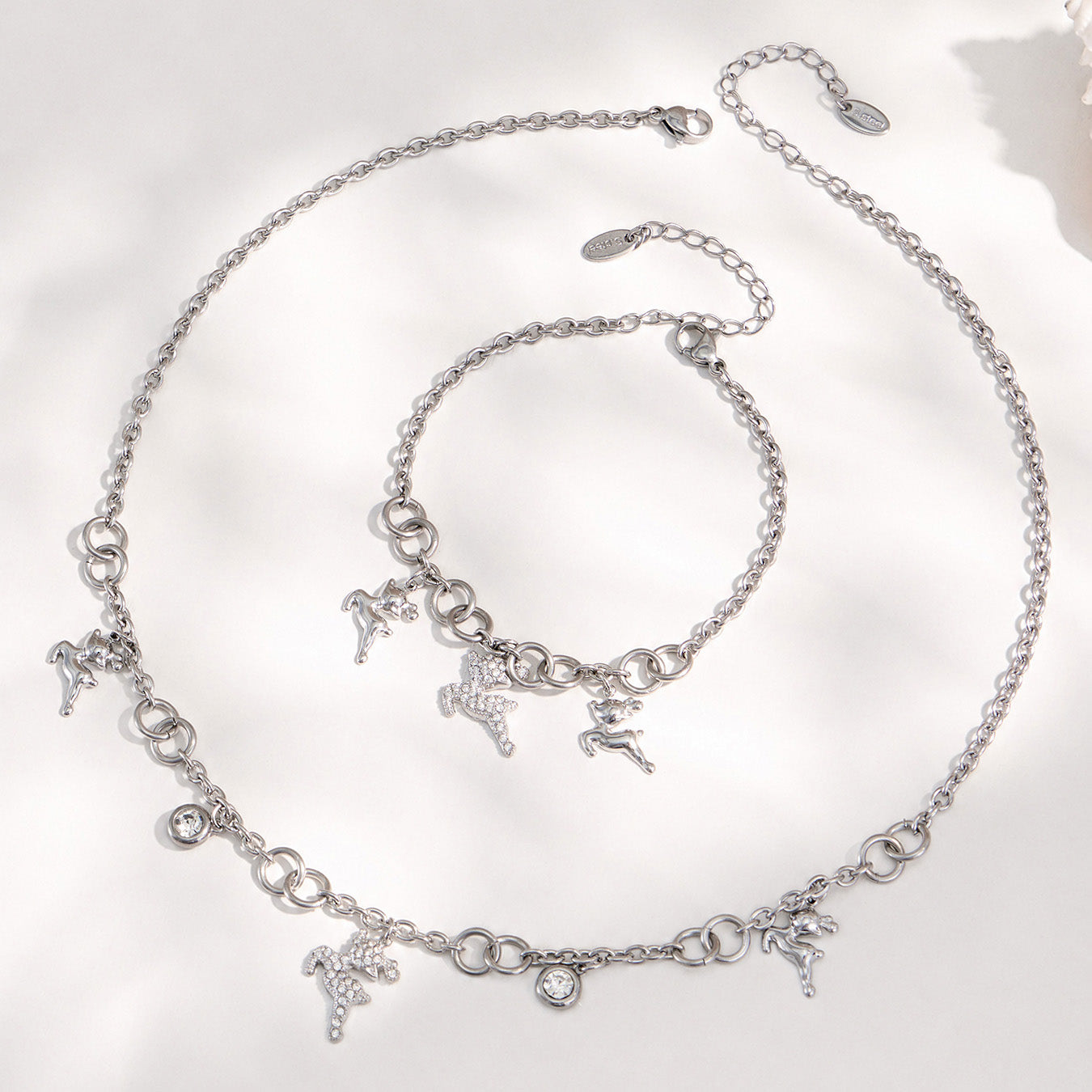 Polished steel reindeer necklace and coordinating deer charm bracelet displayed together