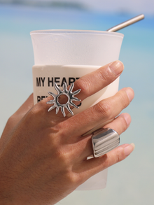 Steel tone sunburst ring and wide band ring modeled with beach drink for daily wear