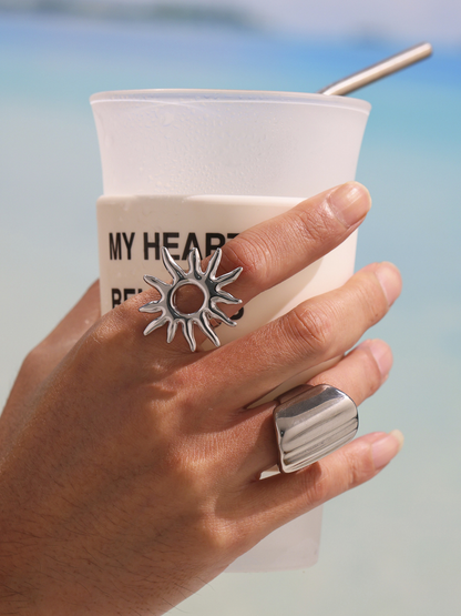 Steel tone sunburst ring and wide band ring modeled with beach drink for daily wear