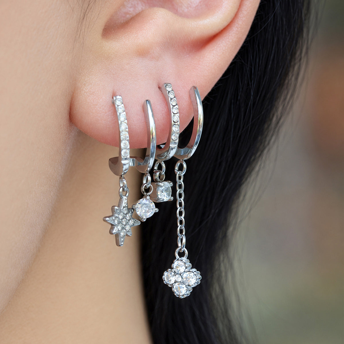Steel-tone stainless steel CZ charm drop earrings worn on ear