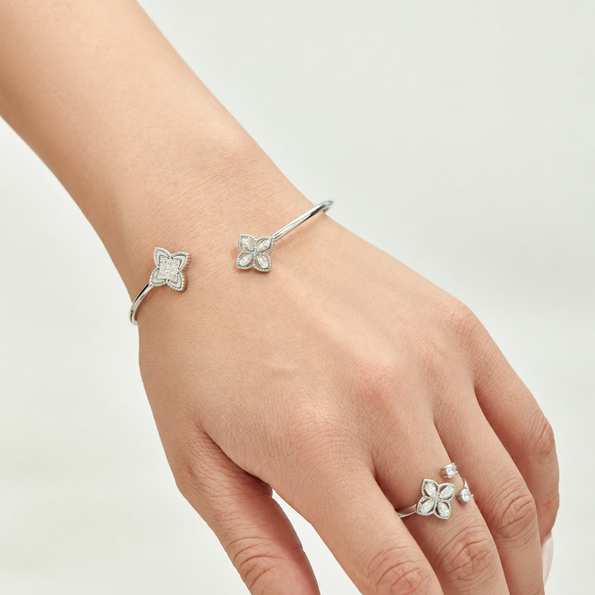 Steel-tone flower open ring and matching bangle styled on the hand and wrist