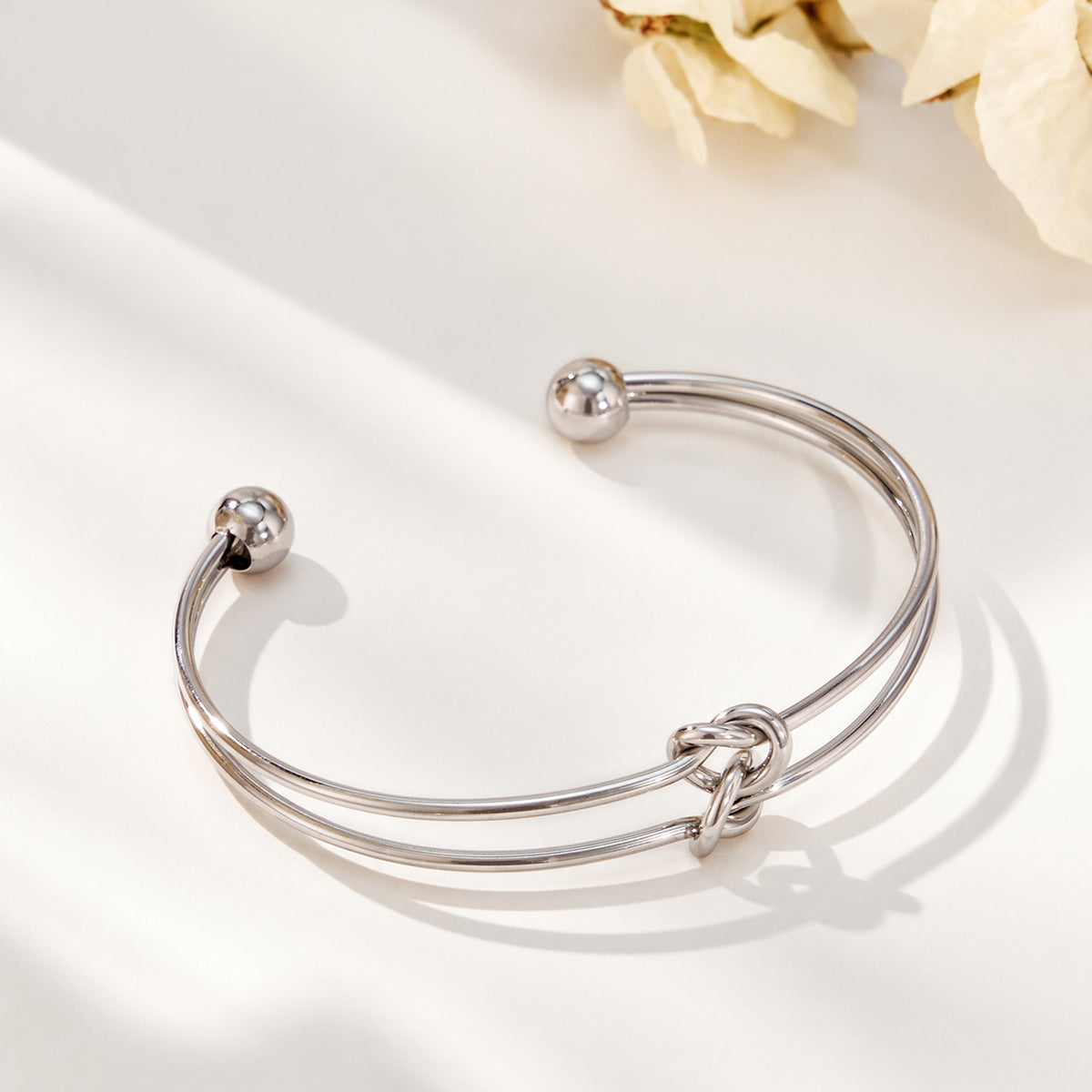 Steel-tone stainless steel open cuff bracelet with minimalist knot design