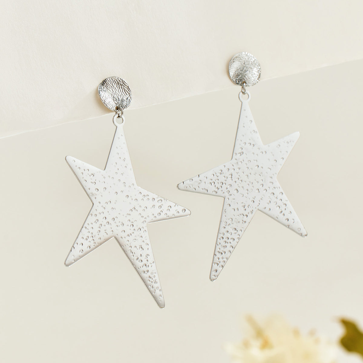 Pair of steel-tone stainless steel star drop earrings with textured five-point star design