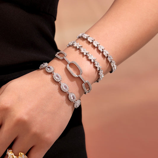 Model wearing a stack of polished steel zircon tennis and link bracelets