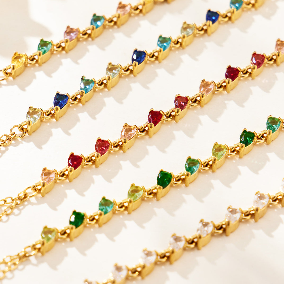 Close-up of teardrop-shaped CZ stones in five hand chain bracelet color options