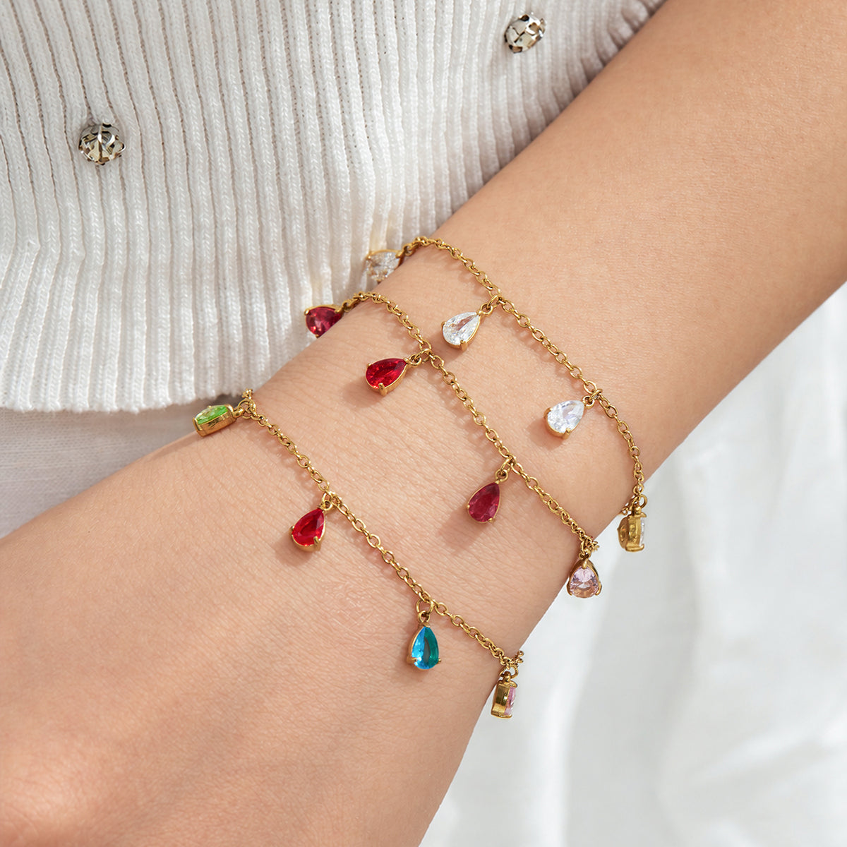 Clear, red and multicolor teardrop zircon bracelets styled together on the wrist