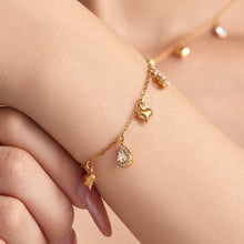 Dainty heart charm bracelet with clear teardrop zircon accents worn on wrist