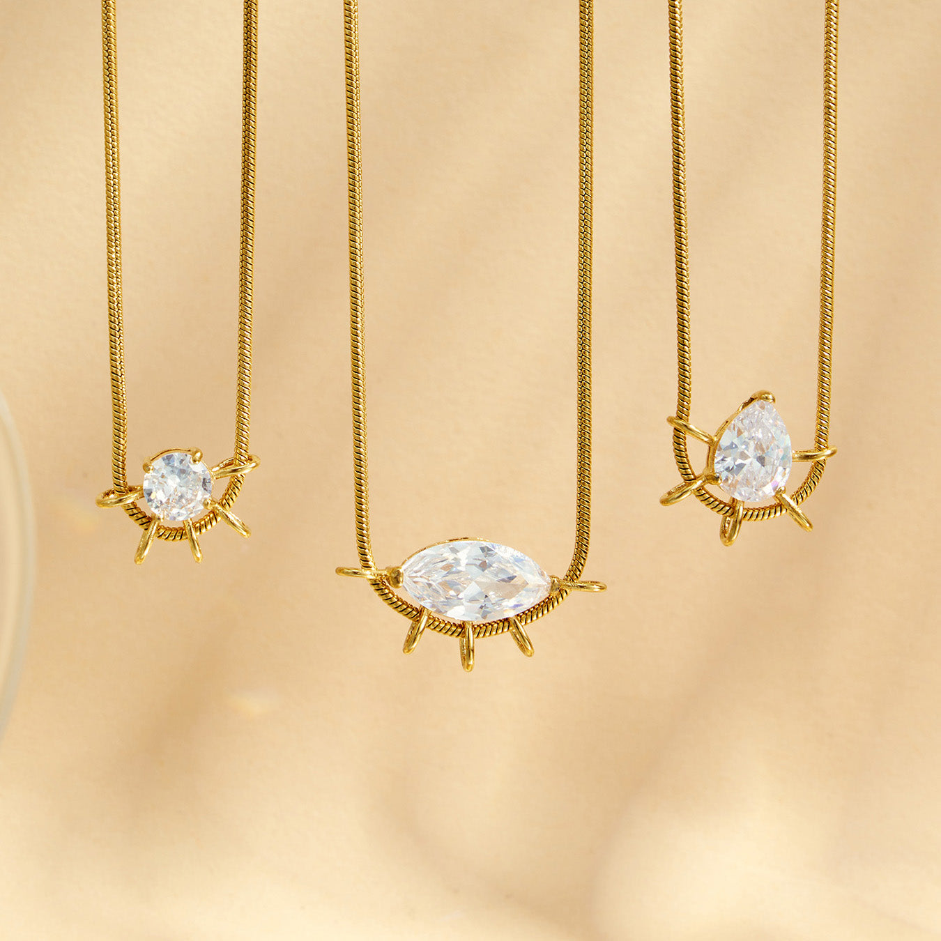 Three geometric zircon pendant necklace styles in round, marquise and teardrop shapes