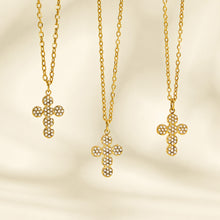 Three gold cross pendant necklace designs displayed vertically on a cream background