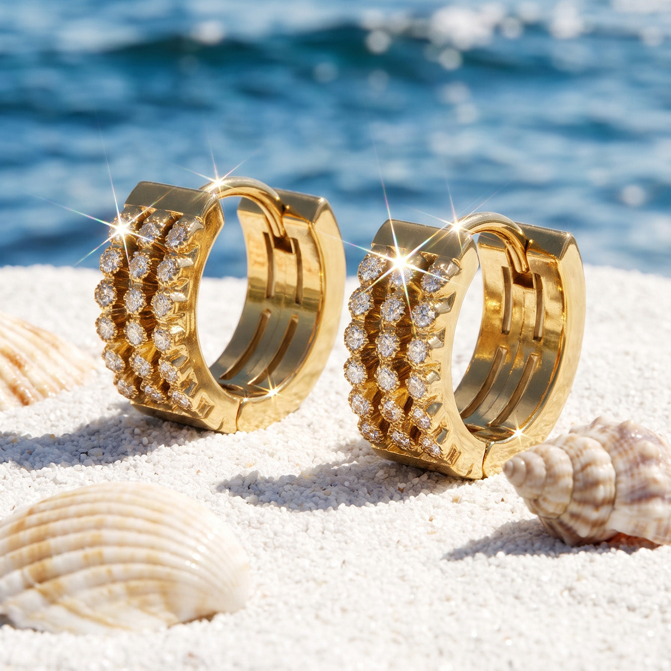 Close-up of gold triple-row huggie earrings in a coastal product setting