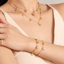 Delicate zircon charm necklace and bracelet styled together on model