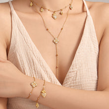 Model wearing gold-tone heart and four-petal flower zircon necklaces and matching bracelets