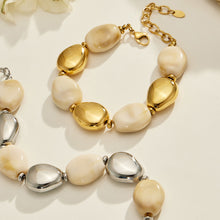 Ivory oval resin bead bracelets in gold-tone and polished steel-tone finishes displayed together on a light surface