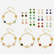 A group display of colorful 316L stainless steel bracelet and earring sets with 18K PVD gold bezel settings.