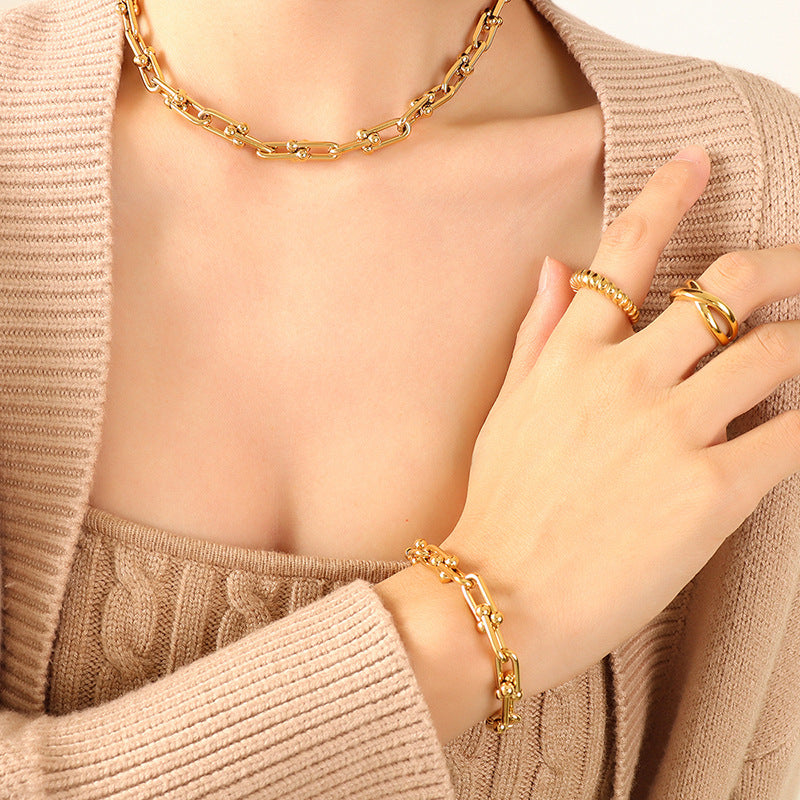 Model wearing a gold U-link chain bracelet on the wrist