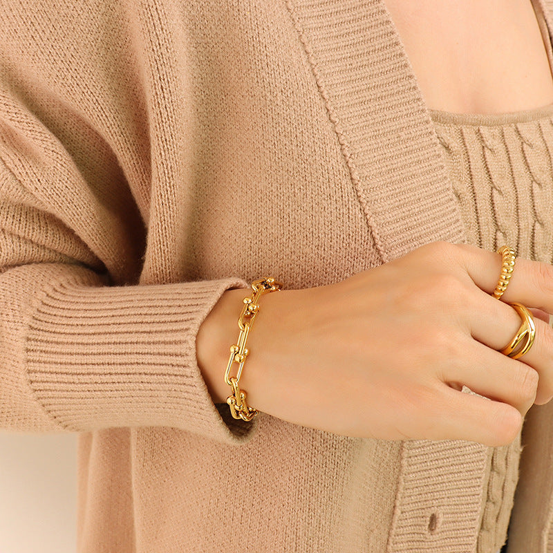 Gold U-link chain bracelet worn as a minimalist everyday accessory
