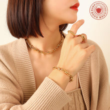 Model wearing a gold U-link necklace in a modern layered jewelry look