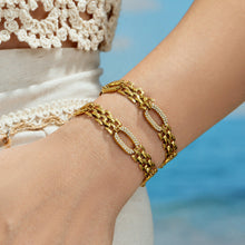 Gold watch band chain bracelet with zircon-set links worn on wrist