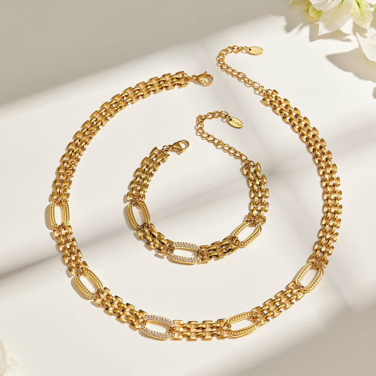Gold watch band chain necklace and matching bracelet flat lay