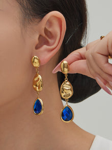 Model wearing hypoallergenic 316L stainless steel sapphire blue Czech crystal teardrop earrings with 18K gold plating.
