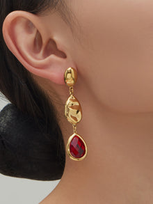 Side profile of model wearing 18K gold plated ruby red water drop hypoallergenic earrings for sensitive ears.