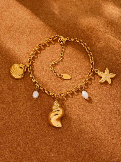 Warm towel flat lay of freshwater pearl shell charm bracelet, waterproof tarnish-free coastal jewelry for wholesale boutiques