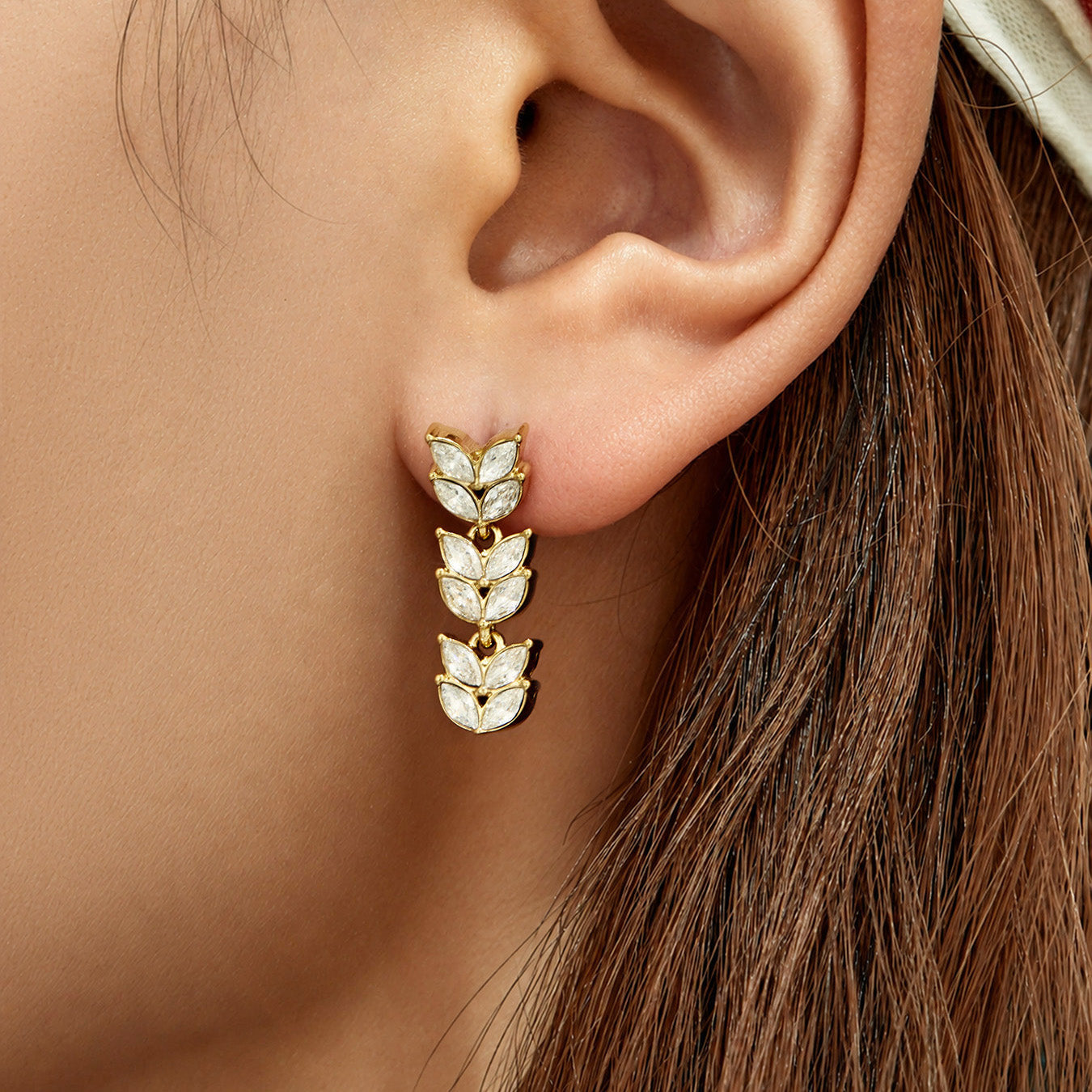 Gold wheat cubic zirconia drop earrings worn on the ear