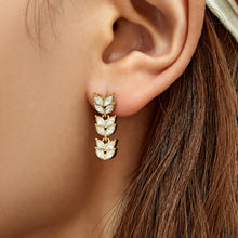 Gold wheat cubic zirconia drop earrings worn on the ear