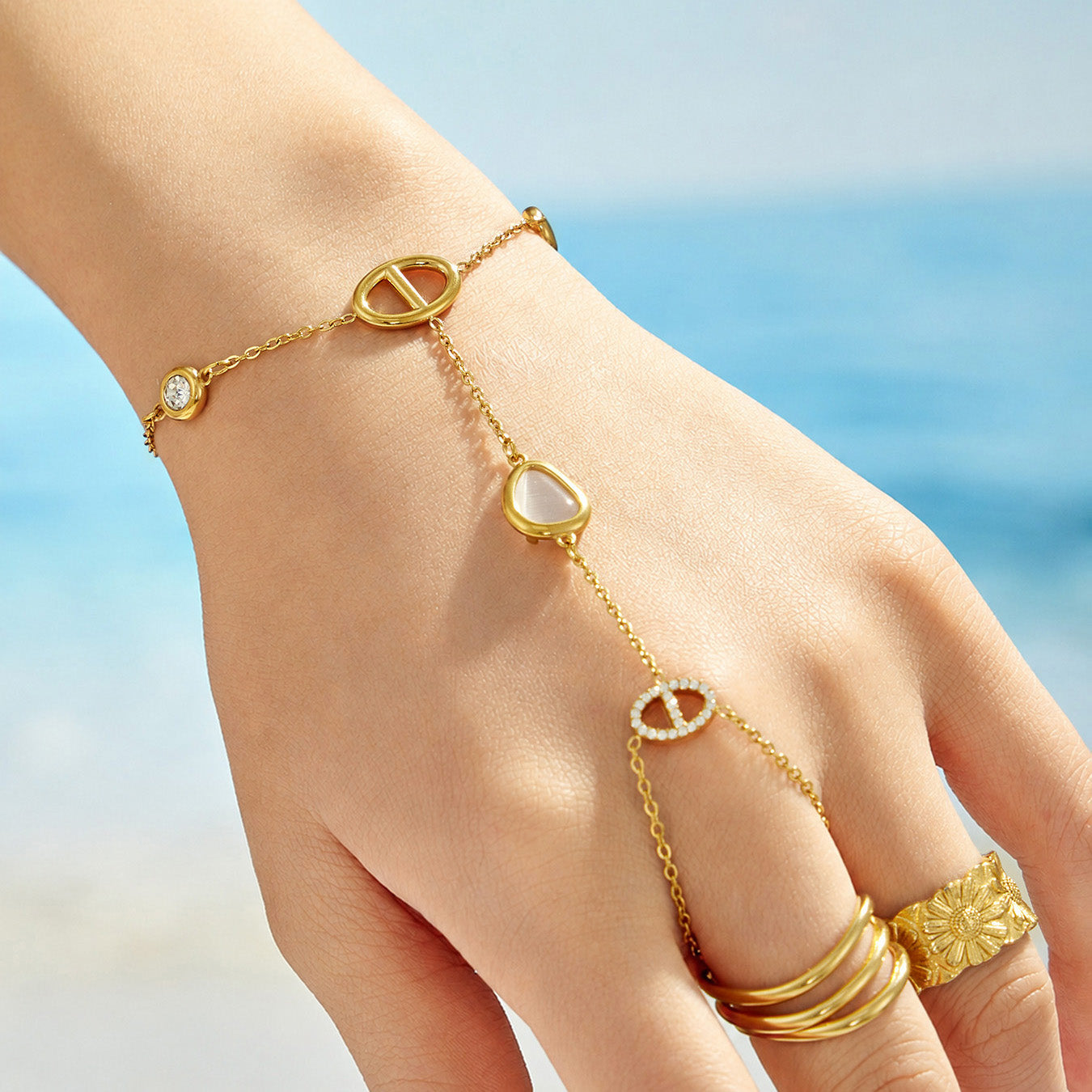 Model wearing a white cat eye double-finger hand chain bracelet