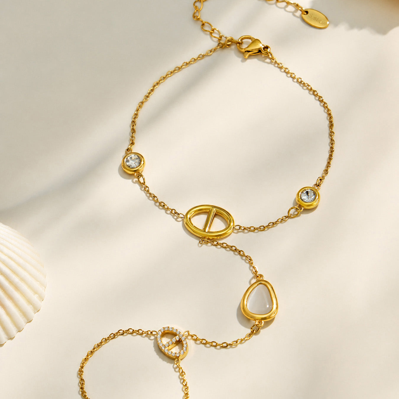 White cat eye hand chain bracelet with geometric D-shaped links on a light background