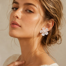 White floral pearl earrings worn by model with soft neutral styling