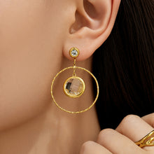 Model wearing white glass stone drop earrings with a gold circular frame