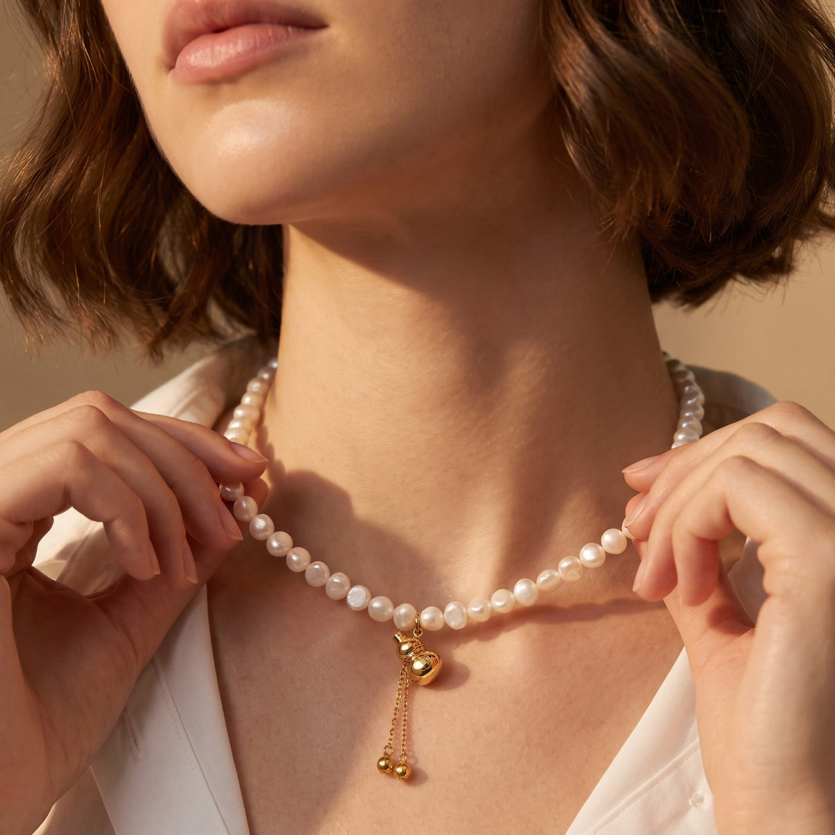 White freshwater pearl gourd pendant necklace worn at the collarbone