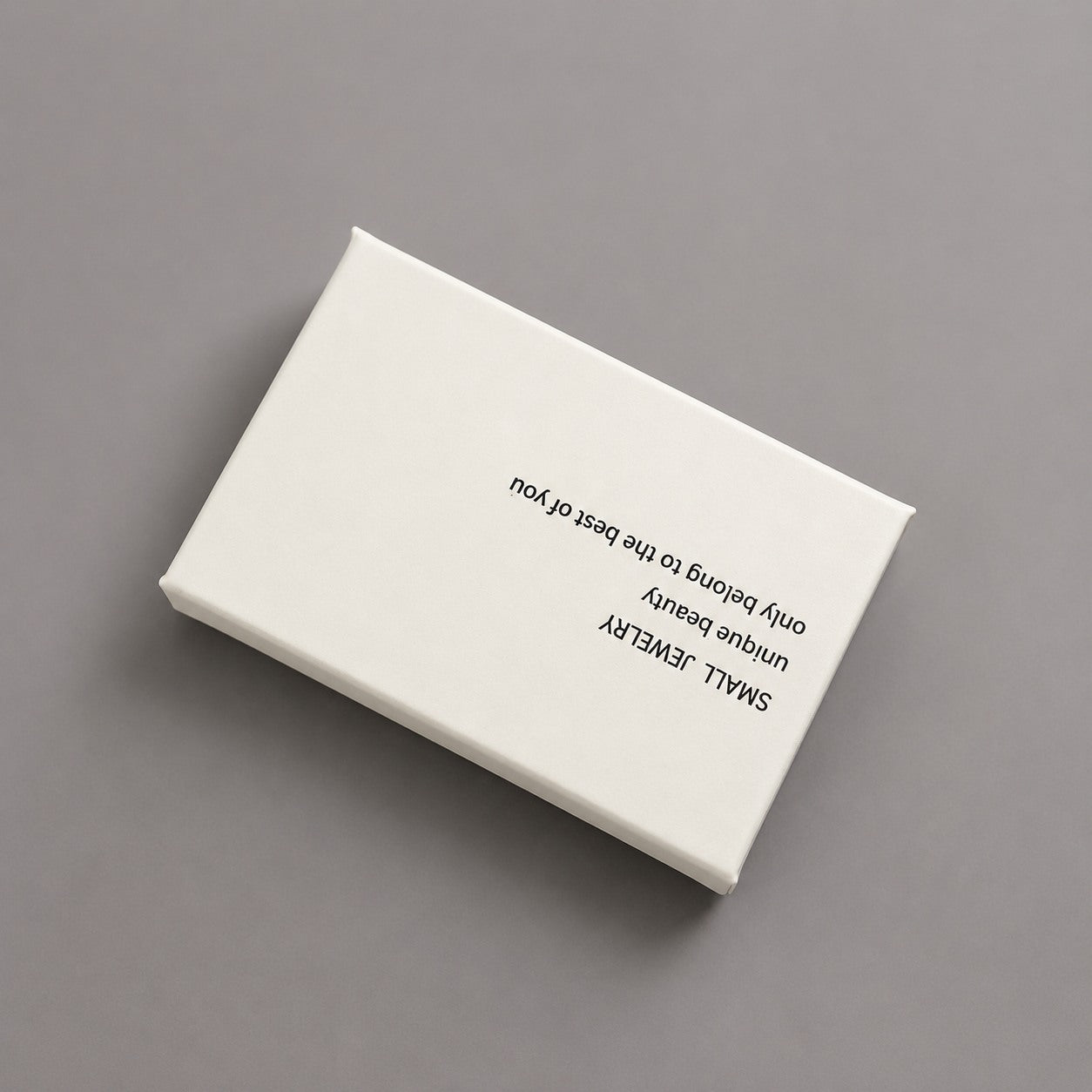 Close-up of a white and blush pink jewelry box with printed lid for boutique jewelry gift packaging