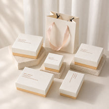 White and pink jewelry boxes with matching paper gift bag for a coordinated retail packaging presentation