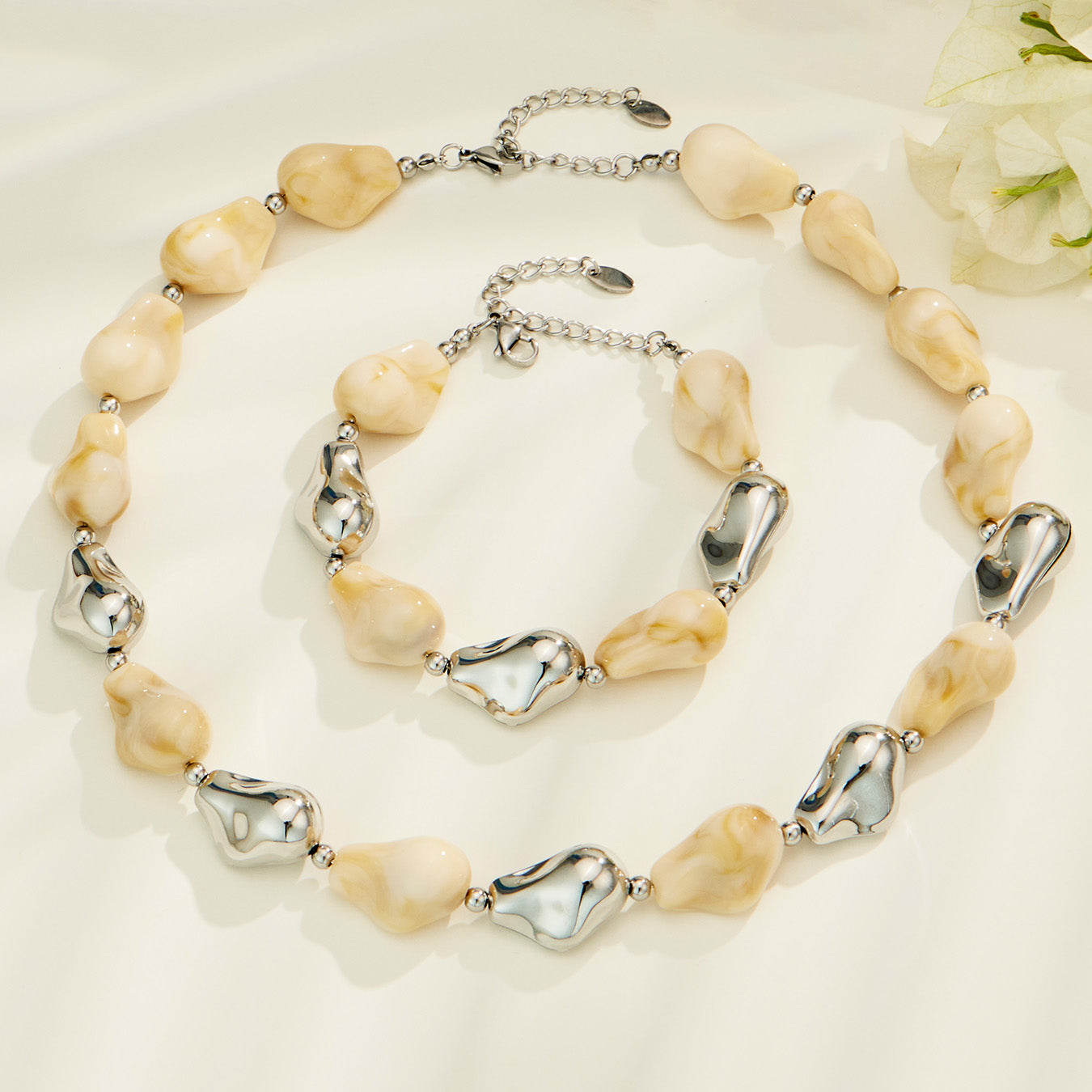 White resin necklace and bracelet set with irregular organic beads and contrasting metal accents