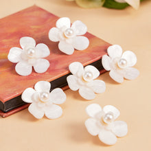 Boutique display of white pearl flower earrings with soft styling
