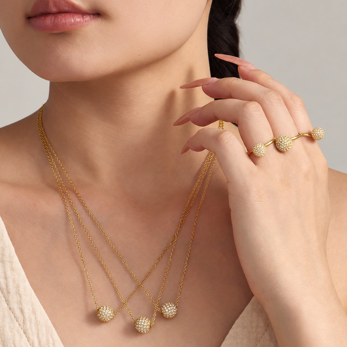 Gold zircon ball necklaces layered on model in delicate everyday styling