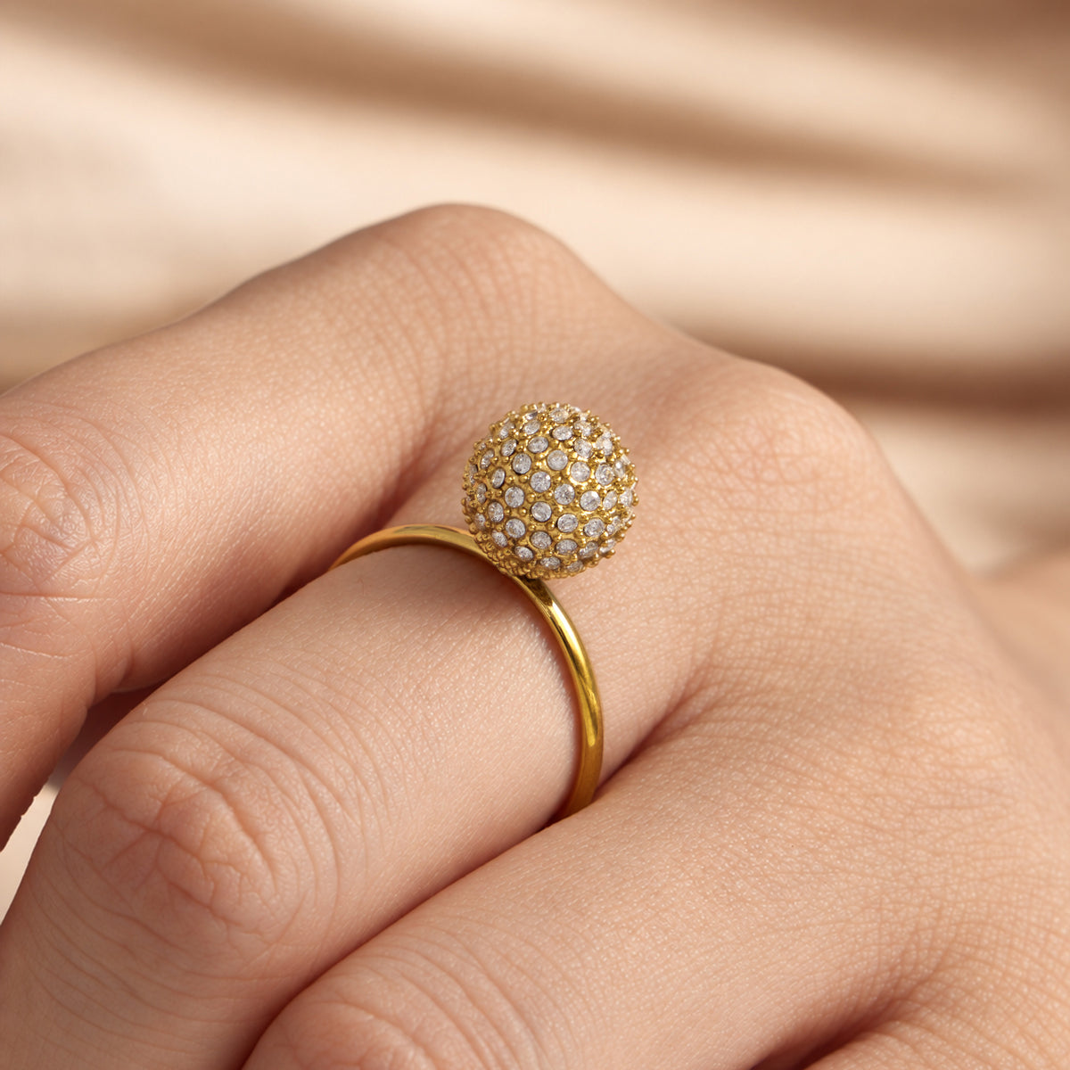 Gold zircon ball open ring worn on finger with pavé round stone detail