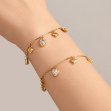 Gold zircon charm bracelets with spaced stone drops worn on wrist
