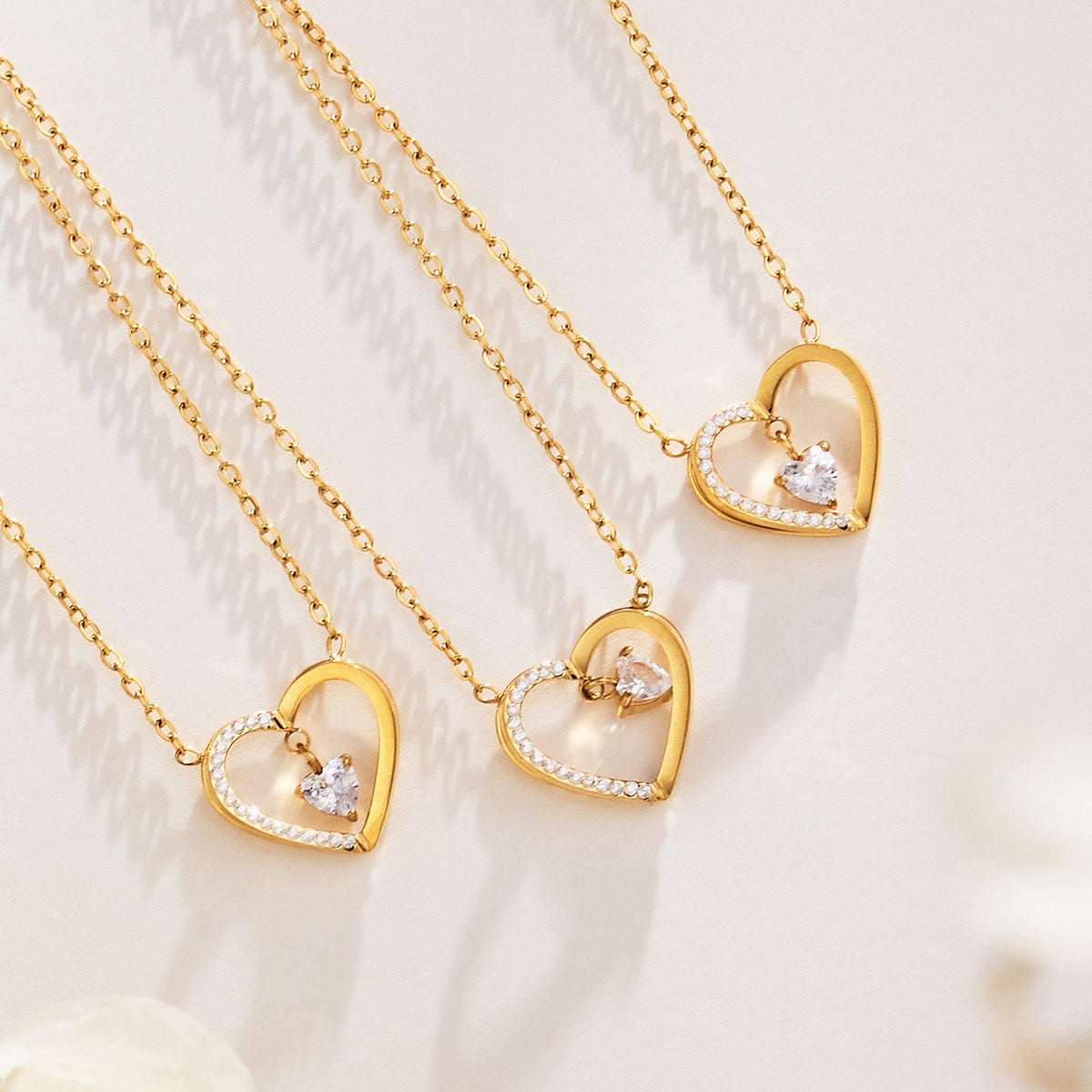 Gold-tone zircon heart pendant necklaces displayed together in a jewelry flat lay
